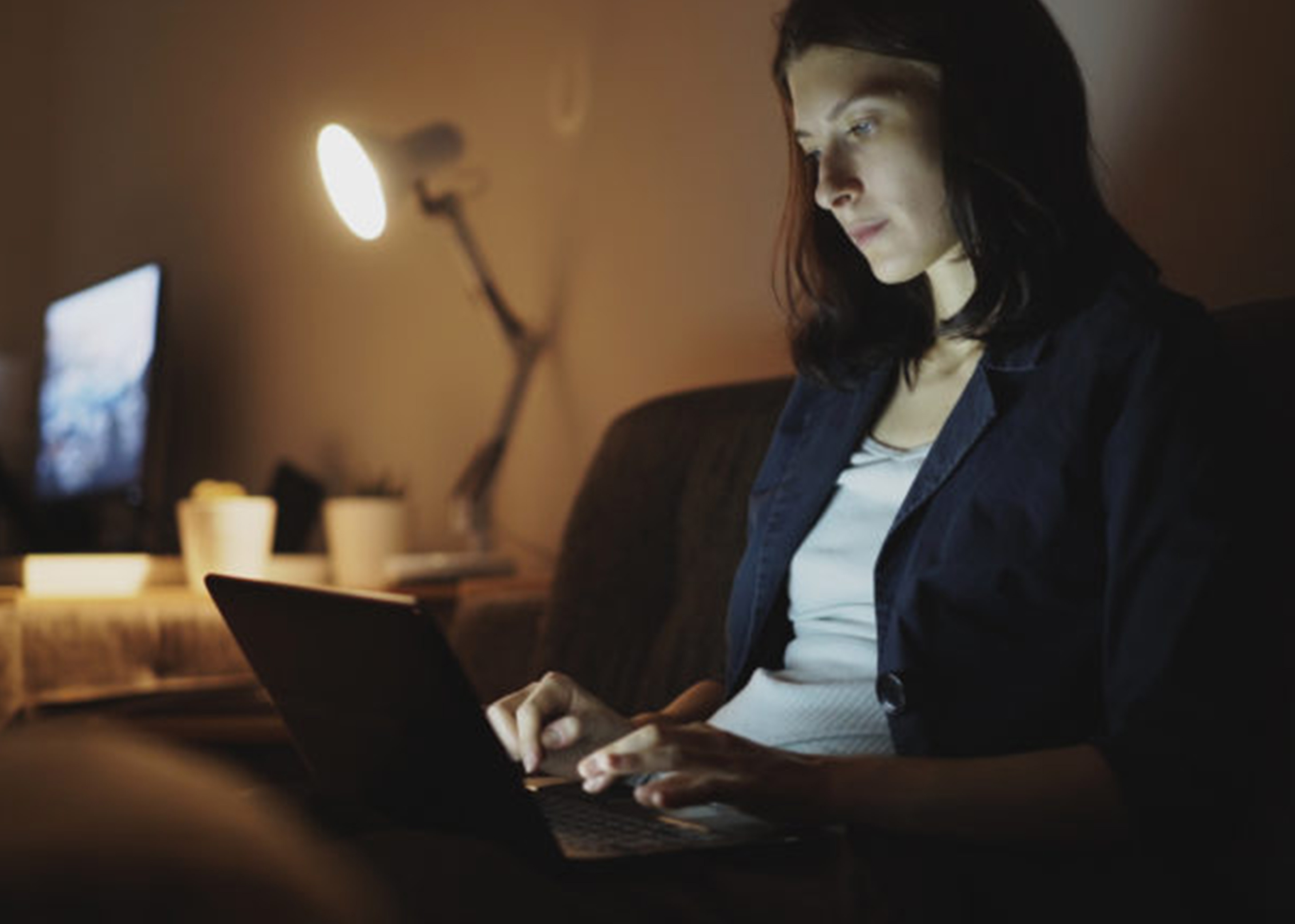 Woman typing on her laptop late at night